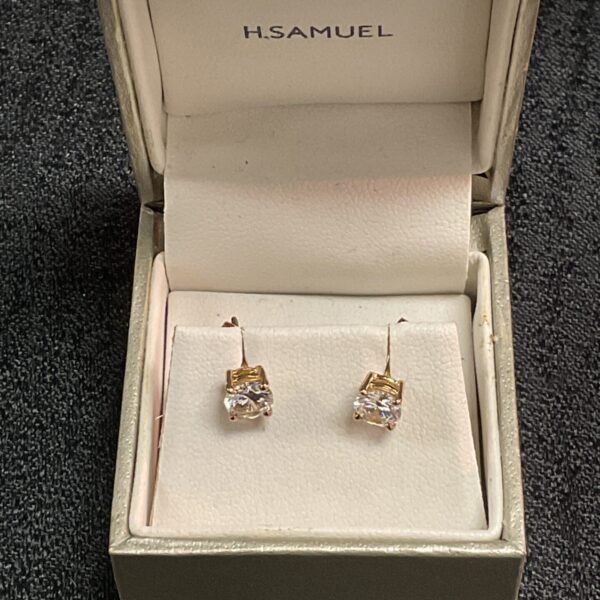 9ct gold cubic zirconia stud earrings on a display cushion.