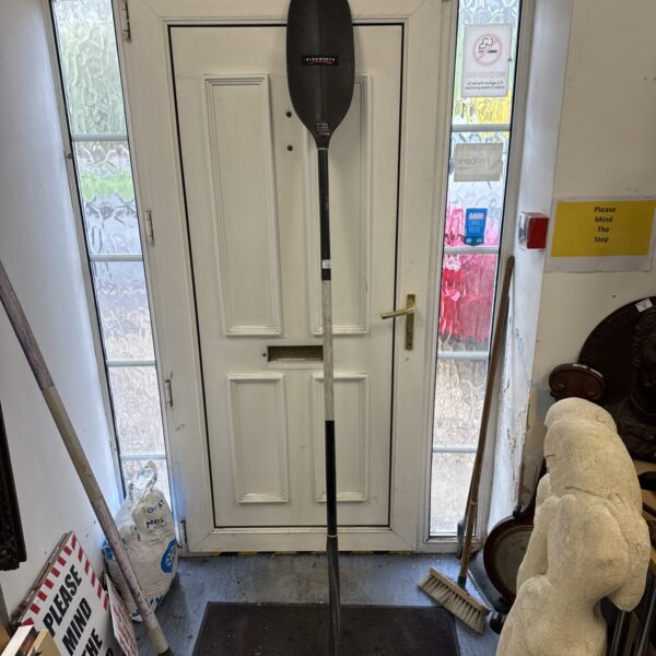 Vintage Ainsworth K100 canoe oar in a doorway.