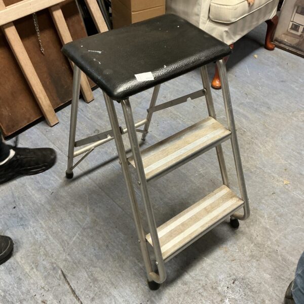Black and silver aluminium kitchen steps, folded and ready for use.