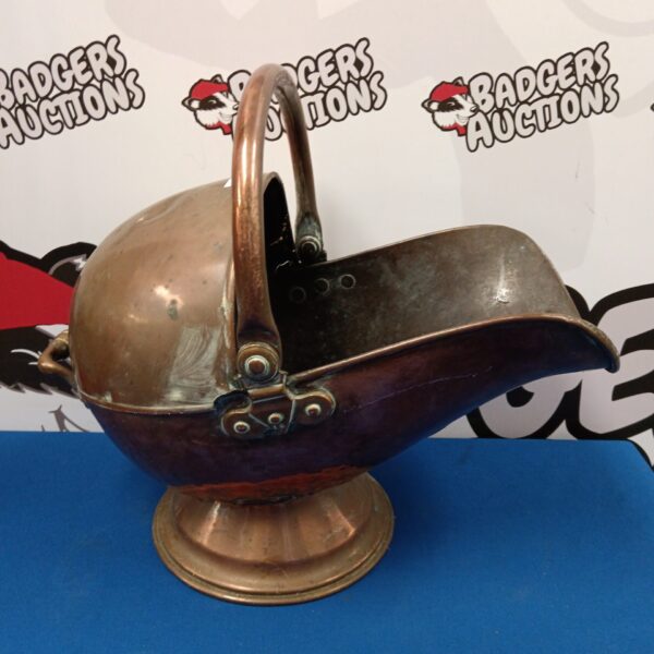 Antique copper coal scuttle with decorative handle and raised base.