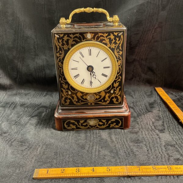 Antique French Capucine clock with brass inlay and visible mechanism.
