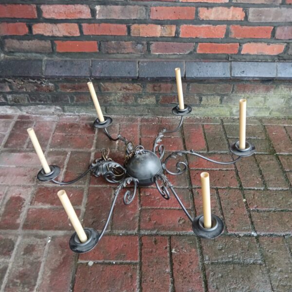 Antique six-arm iron chandelier with gothic detailing.