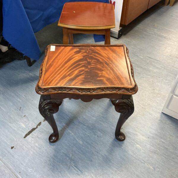 Antique mahogany occasional table with carved legs and circular top.