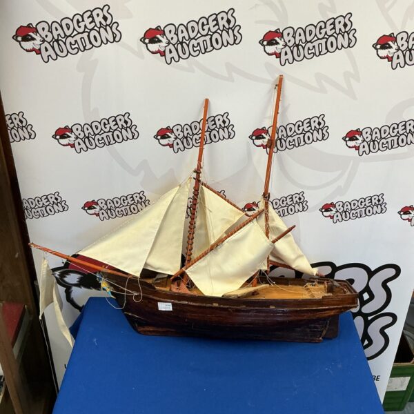 Detailed antique model sailing ship with wooden hull and rigging.