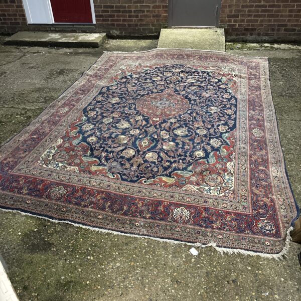 Antique Persian rug with red and blue ground, detailed pattern.