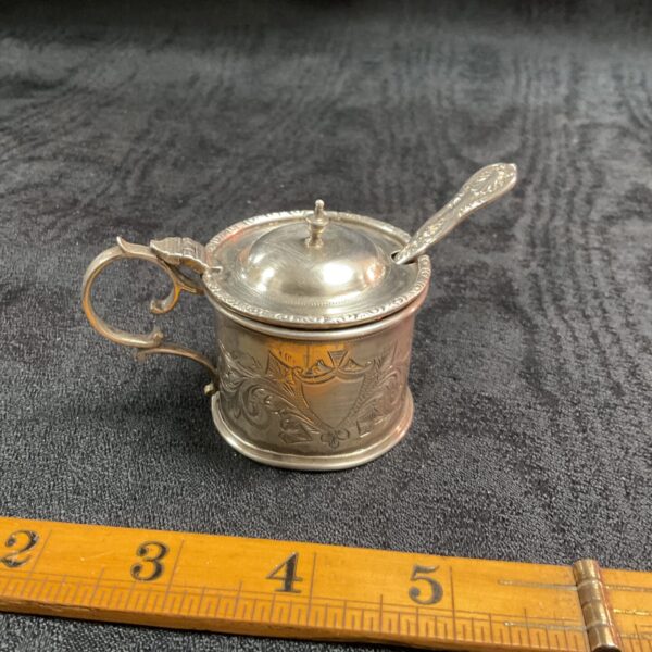 Antique sterling silver mustard pot with embossed detailing.