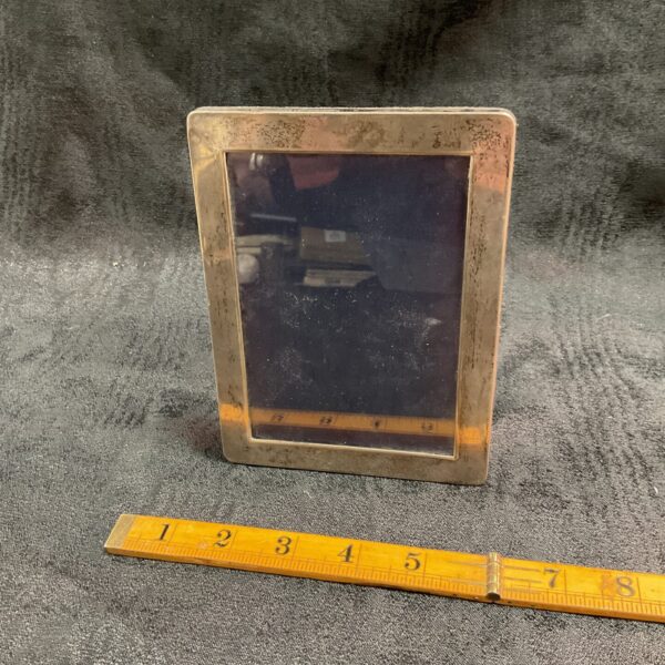 Ornate antique silver photo frame with a dark photograph inside.