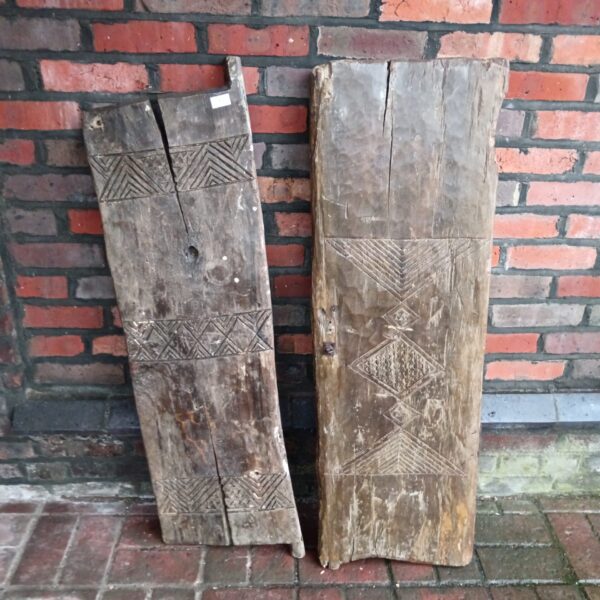 Antique 19th-century hand-carved tribal hut doors with geometric designs.