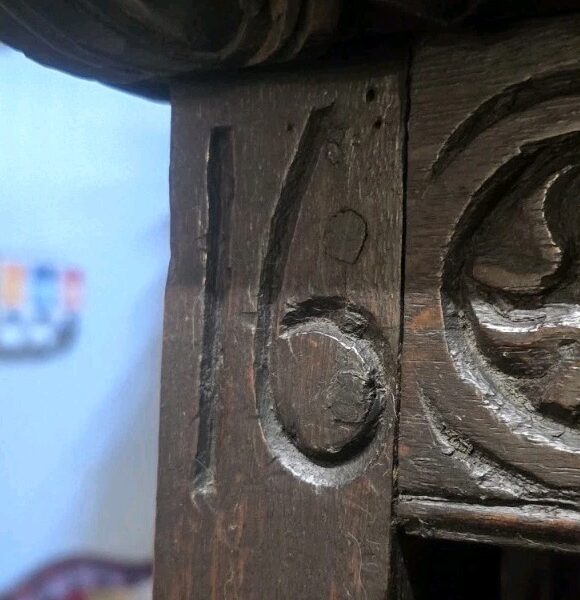 Close-up of antique wooden cabinet carving detail.