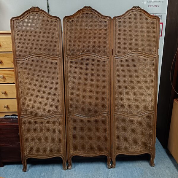 Antique wooden privacy screen with woven cane panels.