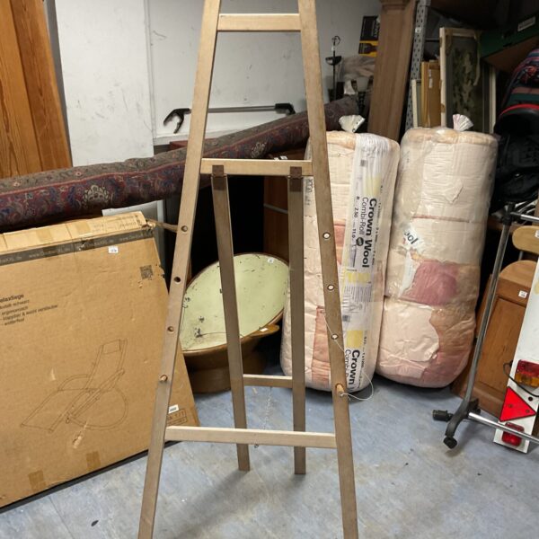Tall wooden artist easel for studio painting and display.