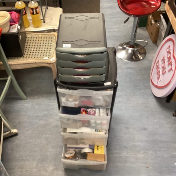 Tiered plastic storage drawers filled with colourful arts and crafts supplies.