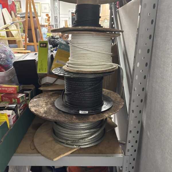 Stacked rolls of assorted vintage electrical cable for projects.