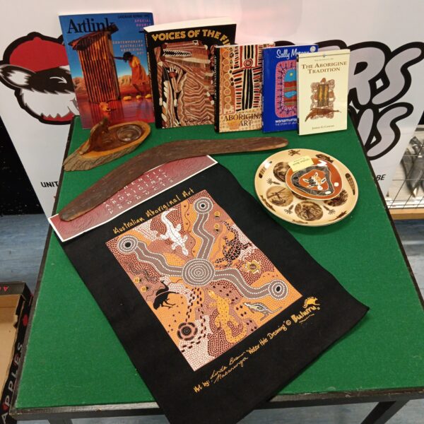 Diverse collection of Australian Aboriginal art, books, and cultural items.