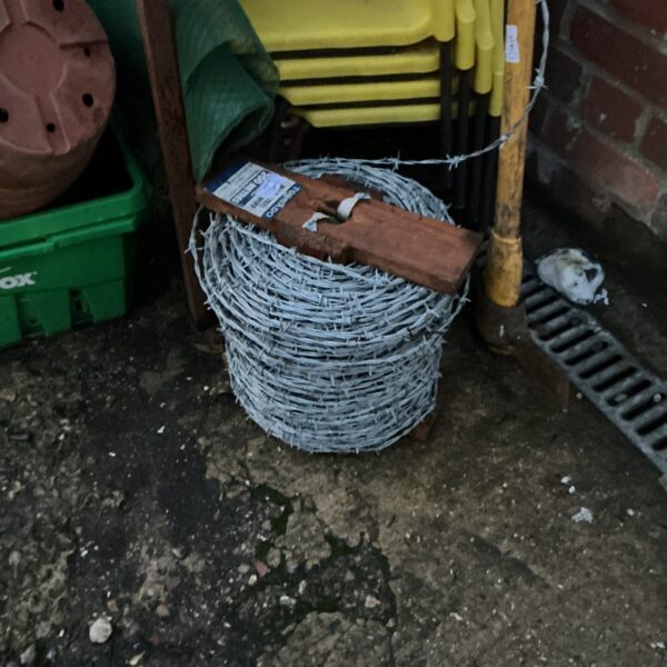 Galvanized steel barbed wire roll for fencing and security.