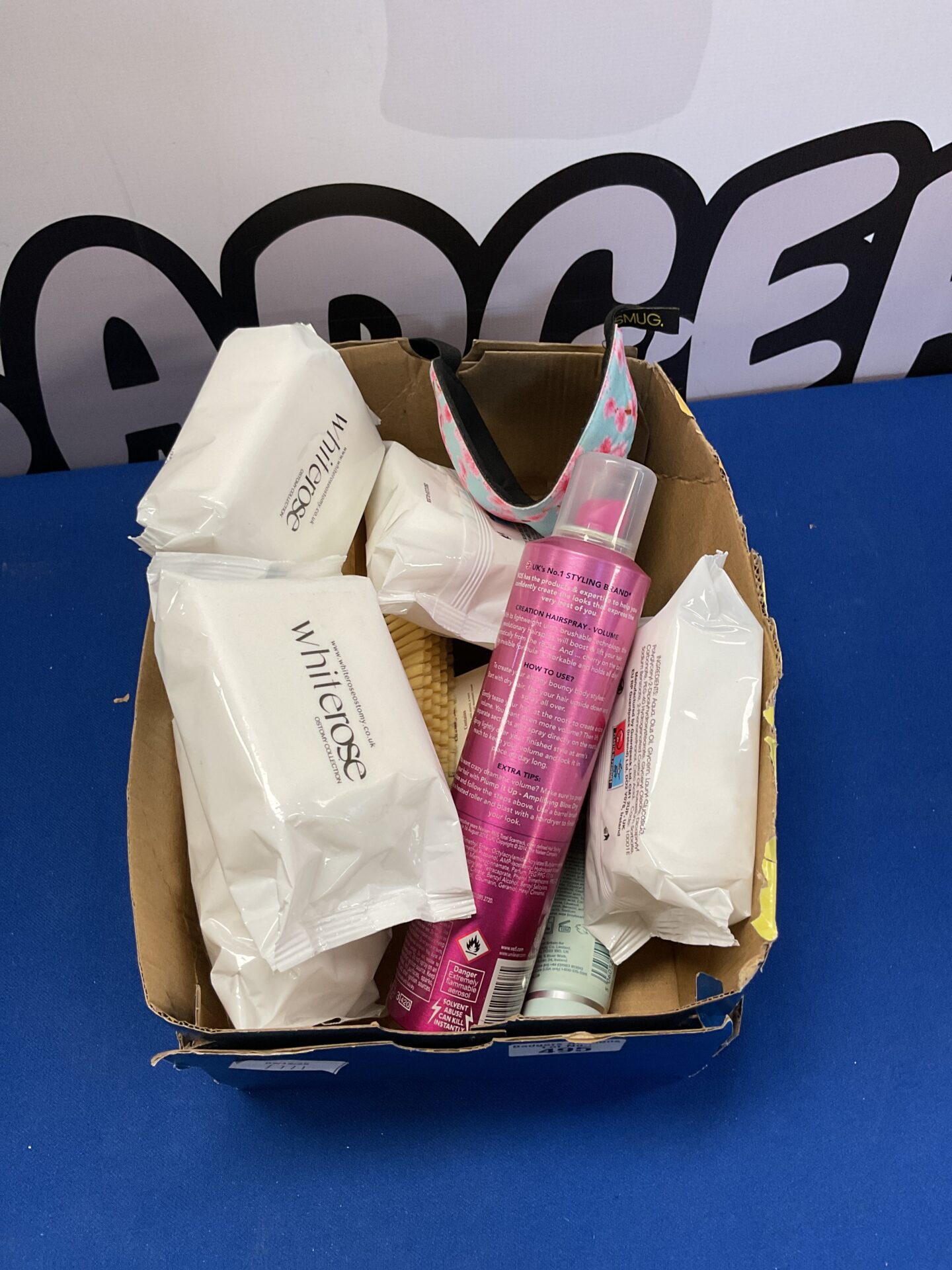 Beauty and haircare lot with hairspray, wipes, and brushes.