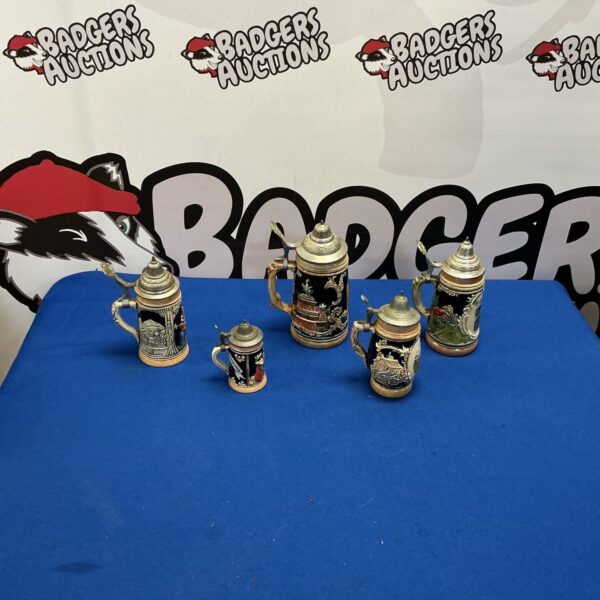 Vintage ceramic bier stein collection with detailed designs.