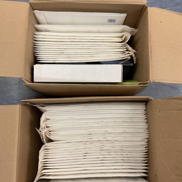 Two boxes of used bubble lined postal bags for shipping.