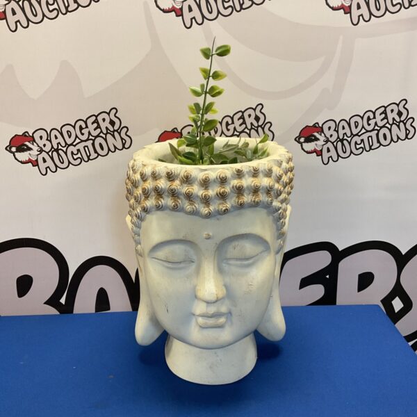 Detailed ceramic Buddha head planter for garden or home decor.
