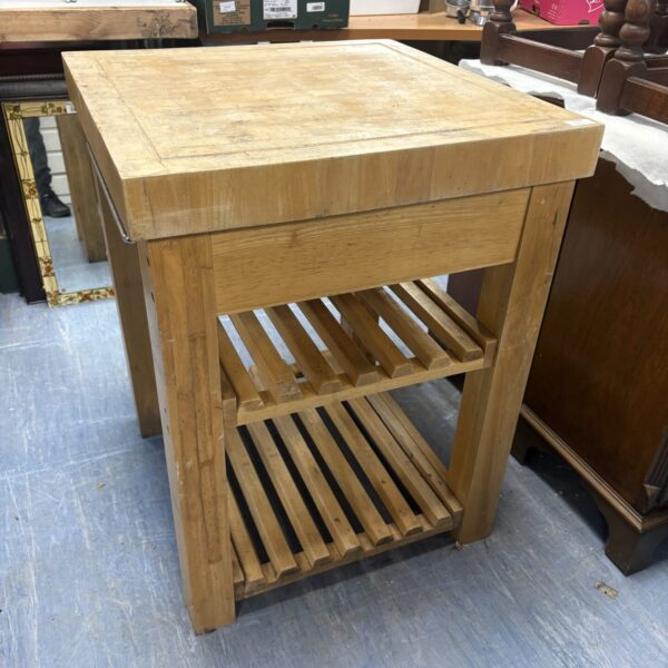 Wooden butcher block kitchen cart with open shelving for storage.