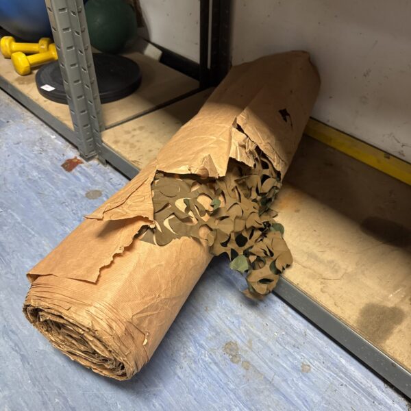 Rolled camouflage netting for outdoor use and concealment.