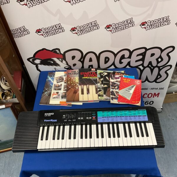 Vintage Casio CA-100 ToneBank keyboard with sheet music.