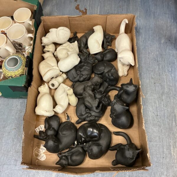 Large collection of vintage porcelain cat figurines on display.