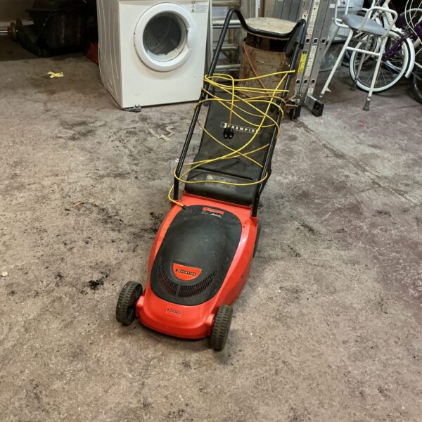 Green and black Champion electric lawnmower in used condition.