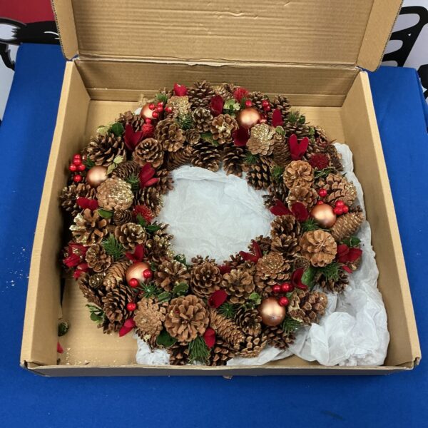 Festive Christmas wreath made of pine cones and red berries.