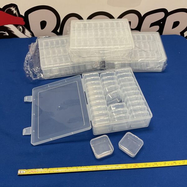 Clear plastic coin storage boxes with compartments for collectibles.