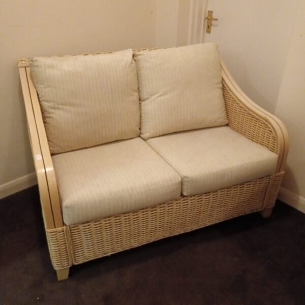 Cream rattan sofa with cushioned seats, vintage style.