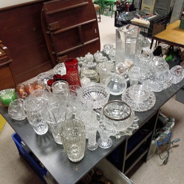 Large lot of vintage crystal and cut glass on a table.