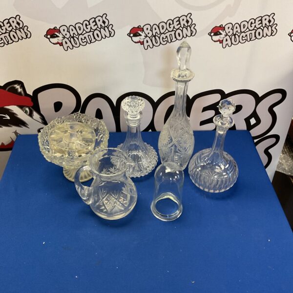 Vintage crystal decanters and pitcher with etched designs.