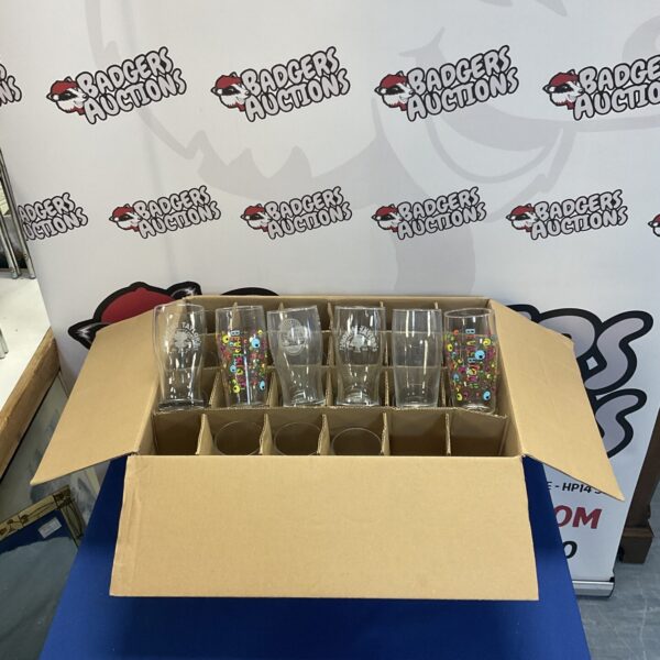 Assorted decorative pint glasses in a cardboard box.