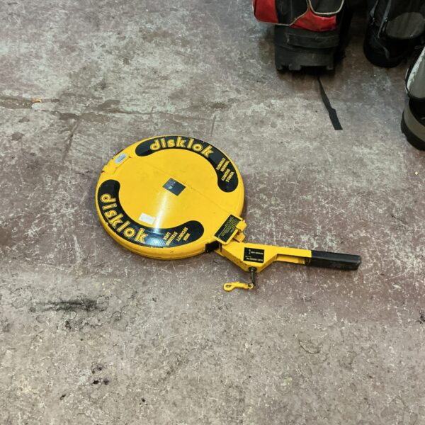 Yellow Disklok steering lock with key, vehicle security device.