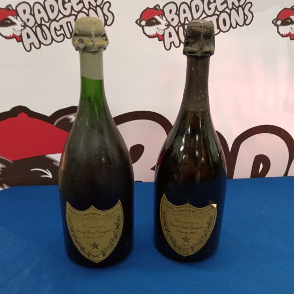 Two sealed vintage bottles of Dom Perignon champagne.