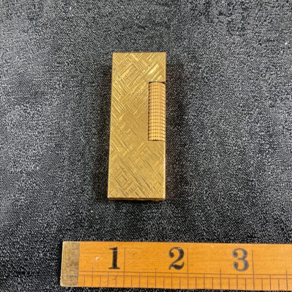 Vintage Dunhill gold plated lighter with textured design.