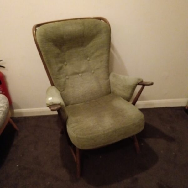 Vintage Ercol armchair with green upholstery and stickback design.