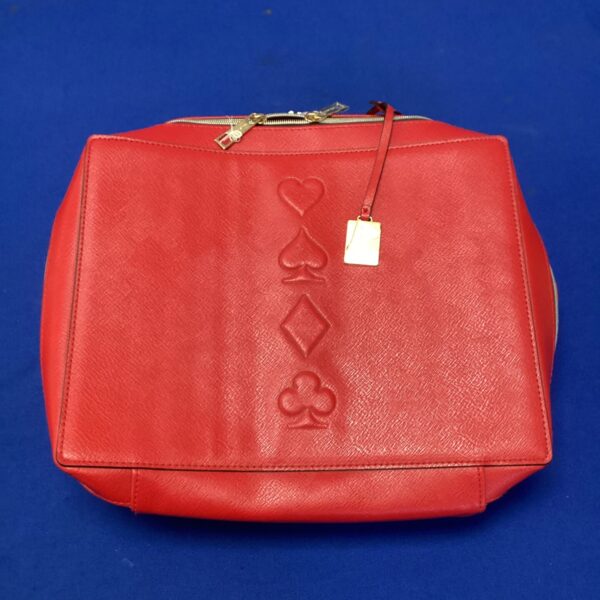 Red Estee Lauder handbag with heart, spade, club, and diamond pattern.
