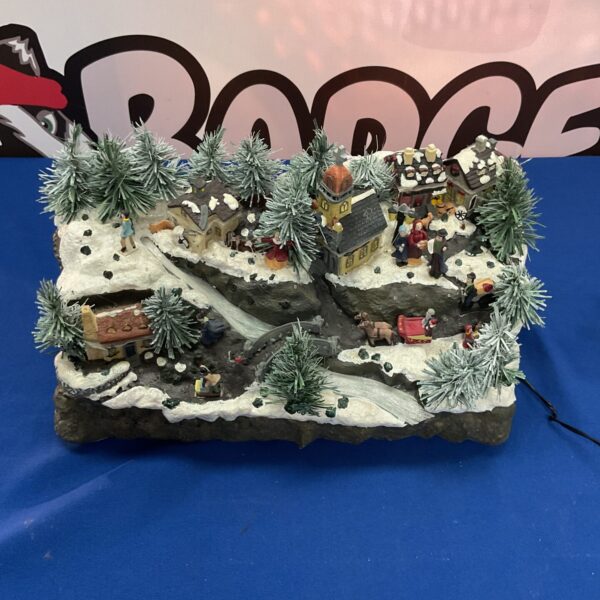 Detailed fibre optic winter village with illuminated buildings and trees.