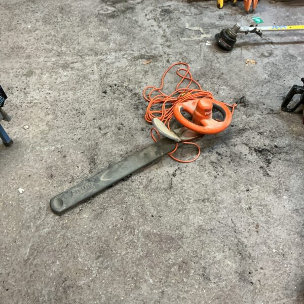 Long handled Flymo electric hedge trimmer for garden use.