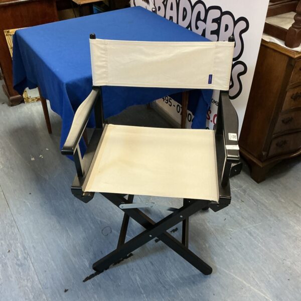 Vintage folding director’s chair with canvas seat and metal frame.