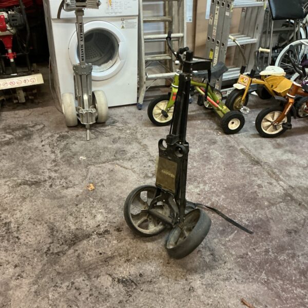 A folded, portable golf trolley for carrying golf clubs.