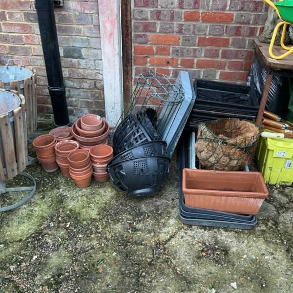 Mixed lot of terracotta and plastic garden pots and planters.