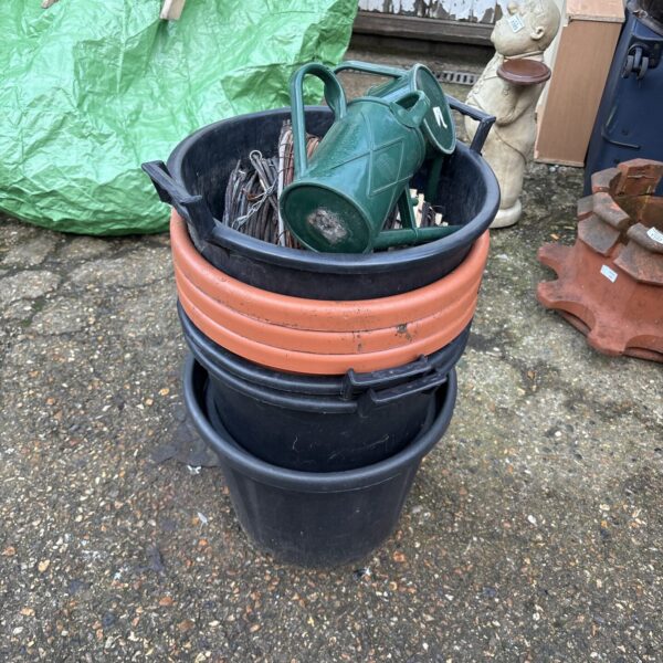 Stacked dark-coloured garden pots with wicker hangers.
