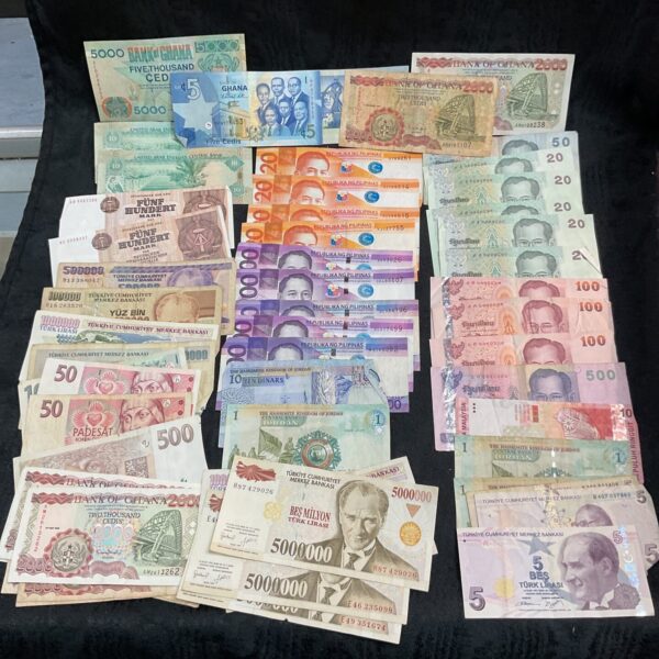 Collection of foreign banknotes including Ghana currency.