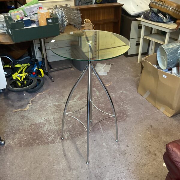 Round glass top table with silver leg, modern home decor.