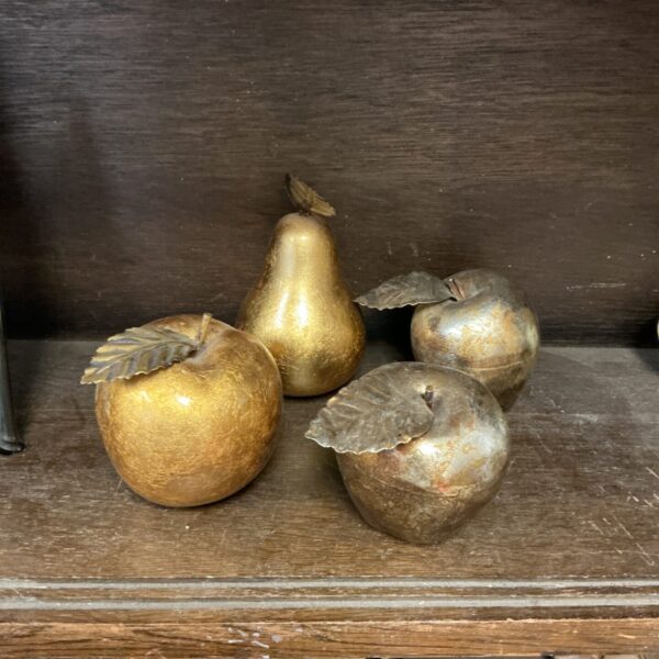 Vintage gold artificial fruit collection on a wooden surface.