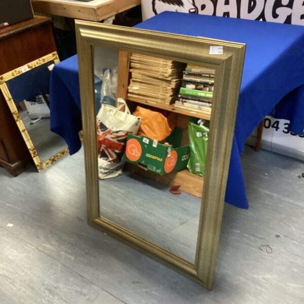 Vintage gold rectangular mirror with decorative frame.