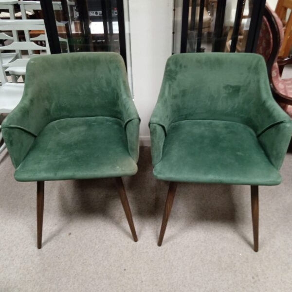 Pair of green tub chairs with metal legs.